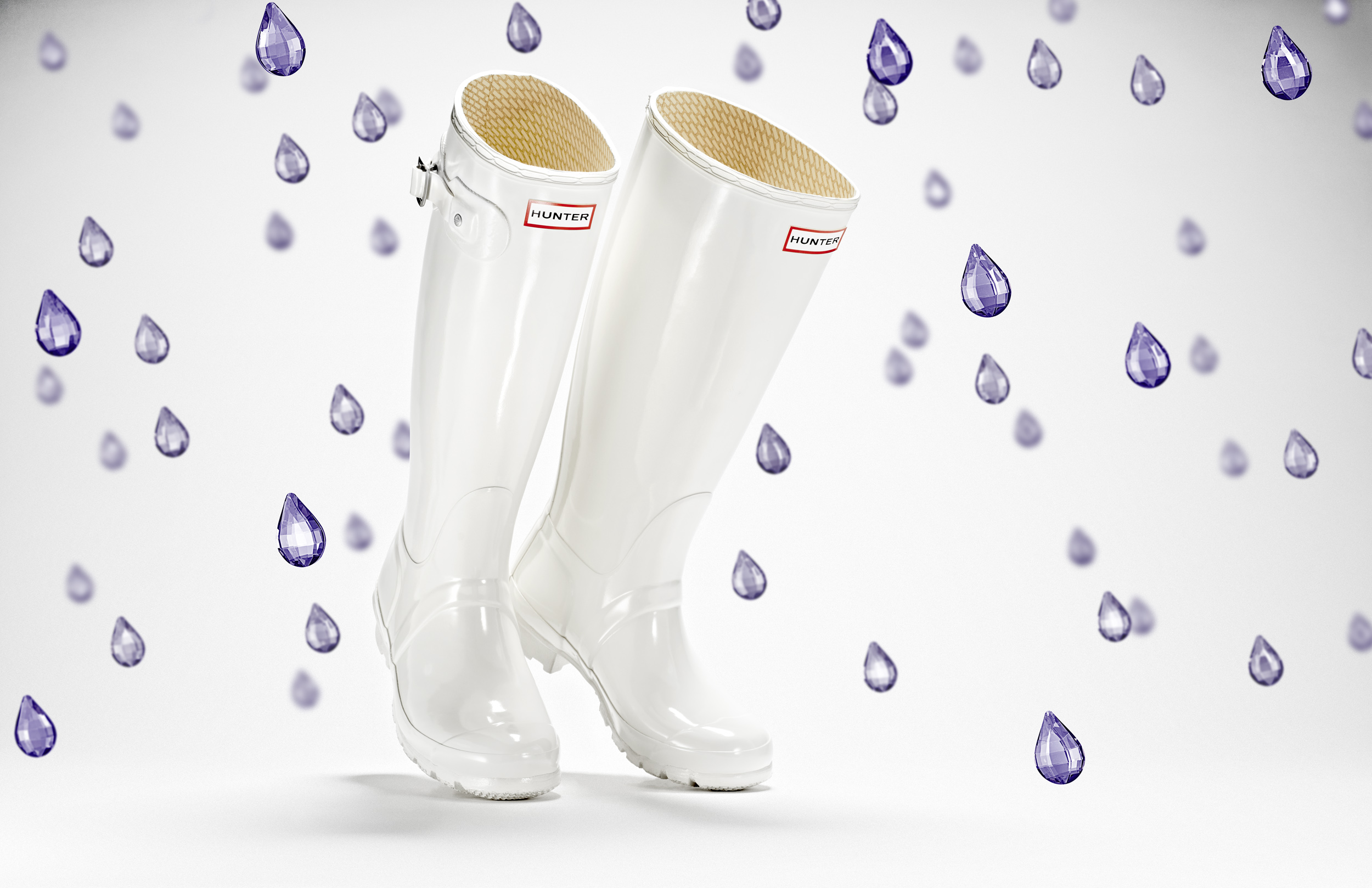 advertising still life photograph of white hunter boots surrounded by purple jewel raindrops