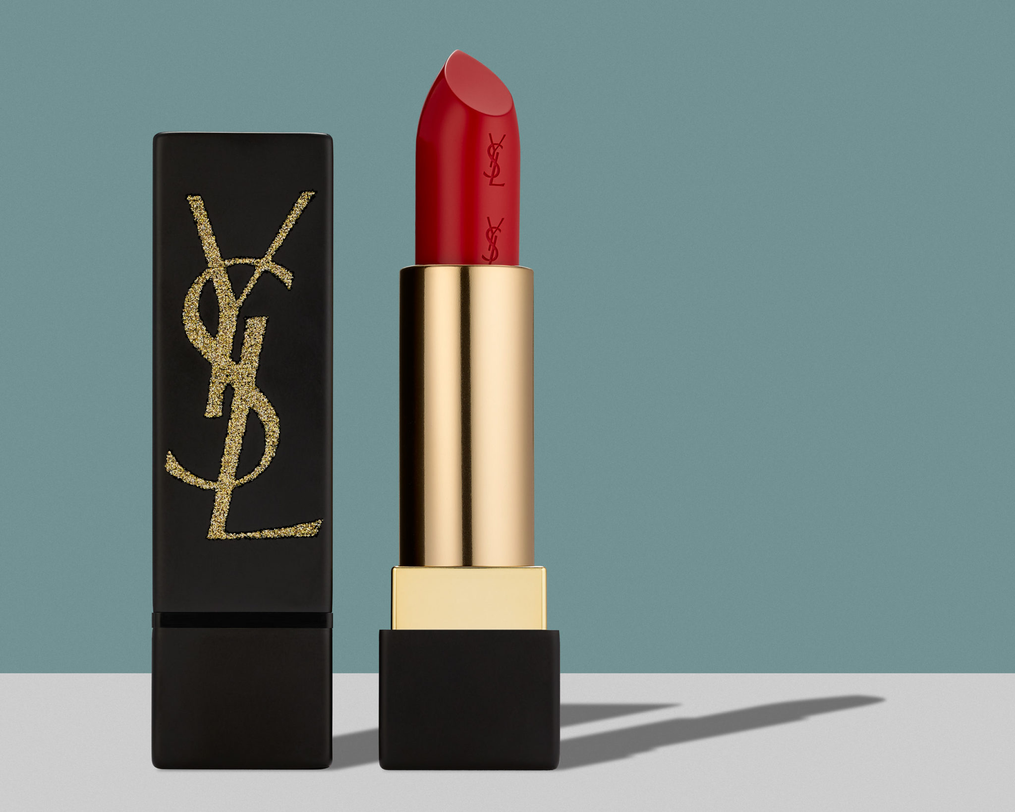 marketing and social media photograph of red YSL lipstick on grey and green background